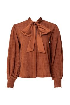 Introducing the Sybil Blouse in Brown! Made with durable brown woven fabric, this blouse features a high neckline with a functional bow for added style. The long balloon sleeve and smocked cuff add a touch of elegance, while the button up style makes it nursing friendly. The perfect addition to your wardrobe - versatile and chic! Just throw on your favorite pair of jeans and you have your new favorite fall outfit. Brown Puff Sleeve Blouse For Fall, Fall Smocked Top With Bishop Sleeves, Fall Smocked Top With Bishop Elastic Sleeves, Chic Smocked Top With Lantern Sleeves For Fall, Fall Smocked Top With Elastic Bishop Sleeves, Chic Lantern Sleeve Smocked Top For Fall, Fall Workwear Tops With Smocked Cuffs, Fall Long Sleeve Smocked Blouse, Fall Long Sleeve Blouse With Smocked Bodice