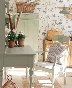 a chair and table in a room with flowers on the wall