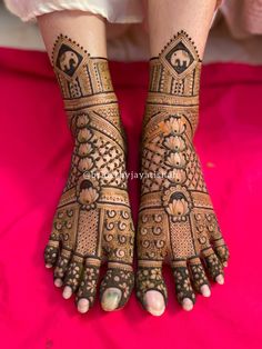 the feet and hands of a woman with henna tattoos