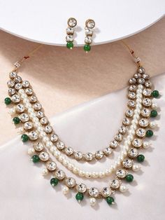 This jewellery set consists of a necklace and a pair of earrings The gold-plated necklace has green beaded layered details Secured with a drawstring closure A pair of matching drop earrings, each secured with a post-and-back closure Size & Fit Earring- 4 cm Necklace-1st layer: 48cm 2nd Layer- 45.5cm 3rd layer: 44cm Material & Care Material: Alloy Plating: Gold-plated Stone type: Artificial stones and beads Care Instructions: Wipe your jewellery with a soft cloth after every use Always store your jewellery in a flat box to avoid accidental scratches Keep sprays and perfumes away from your jewellery Do not soak your jewellery in water Dispatch within 7 days Choker Jewellery, Anarkali Lehenga, Neck Pieces Jewelry, Wedding Jumpsuit, Indian Necklace, Artificial Stone, Neck Piece, A Necklace, Jewelry Choker