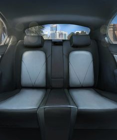 the inside of a car with two seats facing in opposite directions, looking out at a city