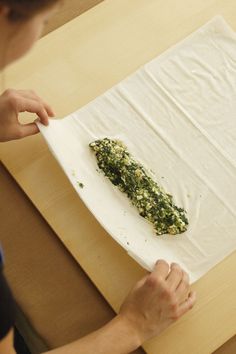 a person is making something on top of a piece of paper that has been folded over