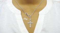 This gorgeous necklace features a cross charm hanging lariat style from an infinity connector for a beautiful look. Cross charm measures about 1 inch long and chain is 18 inches in length with a barrel clasp for closure. Adjustable Cross Lariat Necklace, Cross Lariat Necklace Gift, Elegant Cross Lariat Necklace Gift, Elegant Cross Lariat Necklace For Gift, Elegant Cross Lariat Necklace, Elegant Cross Lariat Necklace As A Gift, Elegant Cross Lariat Necklace With Adjustable Chain, Elegant Cross-shaped Lariat Necklace With Adjustable Chain, Adjustable Silver Cross Lariat Necklace