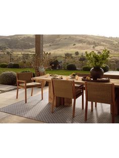 a table and chairs on a patio with mountains in the background