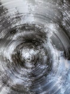 an abstract photo with trees and clouds in the background, as well as a circular design