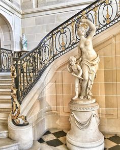 an ornate staircase with a statue on the base