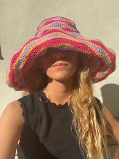 a woman wearing a pink and purple hat