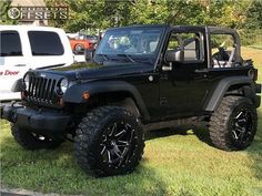 a black jeep is parked in the grass