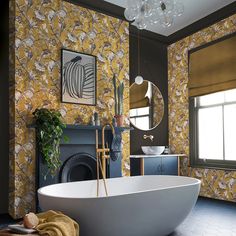 a bath tub sitting in front of a window next to a fire place and mirror