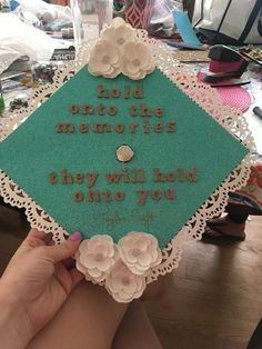 someone is holding up a graduation cap that says hold onto the memories they will hold on you