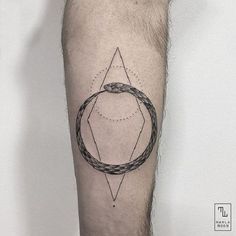 a man's leg with a geometric tattoo on the side of his arm and an arrow in the middle