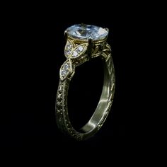 an antique style engagement ring with diamonds on it