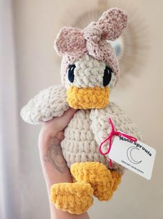 a hand holding a crocheted stuffed duck