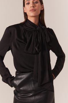 Trends with benefits. The Castian Satin Blouse has a relaxed silhouette that is dramatised by an exaggerated pussybow neckline. Imagined in classic black for a timeless and trans-seasonal look, this blouse is a work to weekend favourite.

SIZING: True to size. AU: Model wears a size 8 / US: Model wears a size 4.

FABRICATION: 100% Polyester

- Satin blouse
- Bow neckline with press stud
- Long loose sleeves Black Bow Tops For Night Out, Black Tops With Bow For Night Out, Black Bow Top For Night Out, Elegant Tie Neck Blouse For Work, Black Tie Neck Top For Evening, Black Tie Neck Blouse For Evening, Silk Workwear Blouse With Bow, Fall Office Wear Blouse With Tie Neck, Silk Top With Bow For Workwear