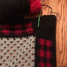 a crocheted bag sitting on top of a wooden floor next to a ball of yarn