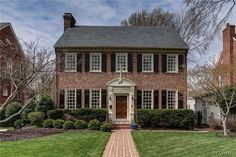 a brick house with white trim and black shutters