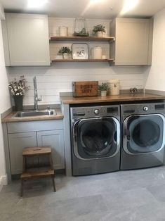 a washer and dryer in a small room with shelves above the washer