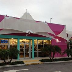 a pink and white building with palm trees in front