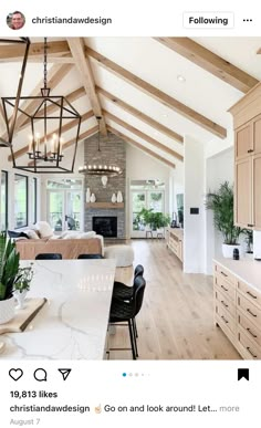 an instagramted photo of a kitchen and living room with wood beams on the ceiling