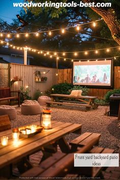 an outdoor movie is set up in the backyard with string lights strung across the fence