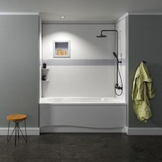 a white bath tub sitting next to a wooden stool