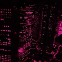 an aerial view of the city at night with pink lights in the buildings and skyscrapers