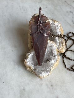 Beautiful wire wrapped and hand woven pendant in antiqued copper with an eye catching Agate Arrowhead. The copper has been patinaed to give it an antiqued look and then hand polished for a final shine. Agate is an excellent stone for rebalancing and harmonising body, mind and spirit. It cleanses and stabilises the aura, eliminating and transforming negativity. Agate enhances mental function, improving concentration, perception and analytical abilities. This pendant series is a collaboration with my son. He has been requesting a pendant a young man could wear for a while now. I look forward to more collaborations with him in the future. All purchases have an 20" black nylon waxed cord and 24" antique copper ball chain necklace included. Bohemian Brown Arrowhead Jewelry, Wire Wrap Arrowhead, Arrowhead Necklace, Ball Chain Necklace, Beading Wire, Wrapped Pendant, Black Nylon, Wire Wrapped Pendant, Copper Jewelry