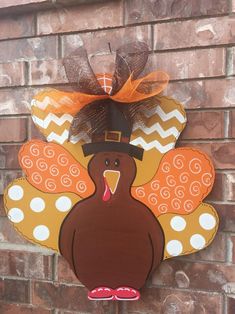 a wooden turkey with a top hat on it's head hanging from a brick wall