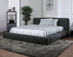 a bed sitting on top of a wooden floor in a bedroom