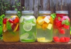 four mason jars filled with different types of fruit