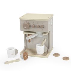 an old fashioned coffee maker with cups and spoons next to it on a white background