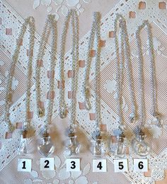 several necklaces are laid out next to each other on a lace covered tablecloth