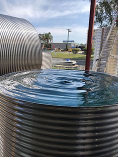 a large metal barrel filled with water next to a building