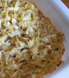 a casserole dish with noodles and cheese on top in a white baking dish