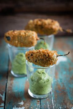 three small cups filled with food on top of a wooden table