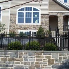 a brick house with black iron fence and gate