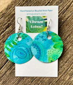 pair of blue and green earrings with the words, vibrant looks? on it's ear