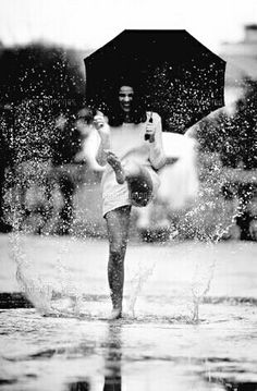 a man standing in the rain holding an umbrella