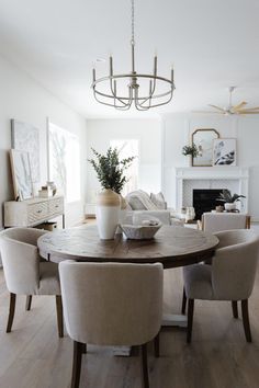 a dining room table with chairs around it and a vase on the top of it