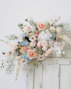 a bunch of flowers that are on top of a white door frame, against a white wall