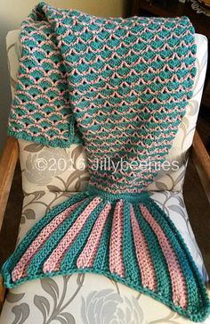 a knitted blanket sitting on top of a chair next to a pillow and throw