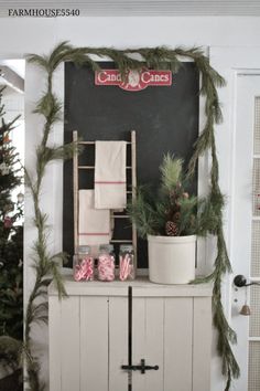 a christmas display with candy canes and pine cones on the top, in front of a chalkboard