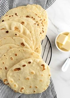 several flat breads on a cooling rack with butter