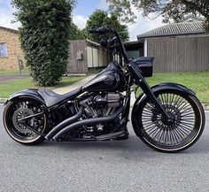 a black and gold motorcycle parked in front of a house on the side of the road