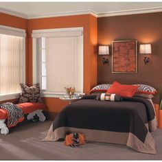 an orange and brown bedroom with zebra pillows