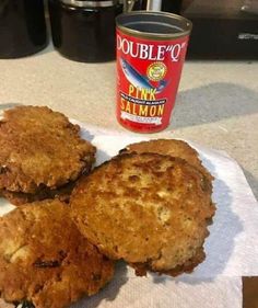 three biscuits sitting on top of a paper towel next to a bottle of pink salmon