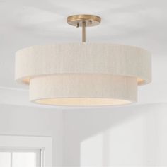 a light fixture hanging from the ceiling in a room with white walls and flooring