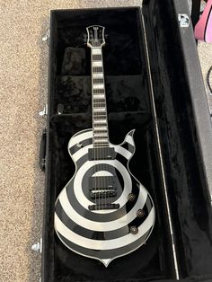 an electric guitar in a case on the ground