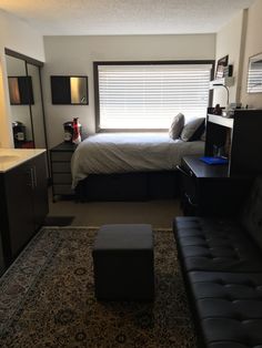 a room with a couch, bed and desk in it