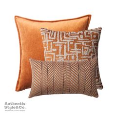 two orange and brown pillows sitting next to each other